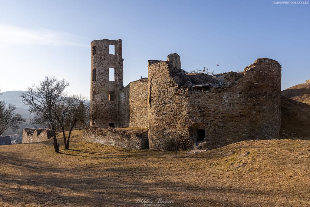Zamek Plaveč 2 Zamek Plaveč, ruiny kamiennej warowni na wzgórzu w Słowacji, widok na mury, baszty i wysoką wieżę.