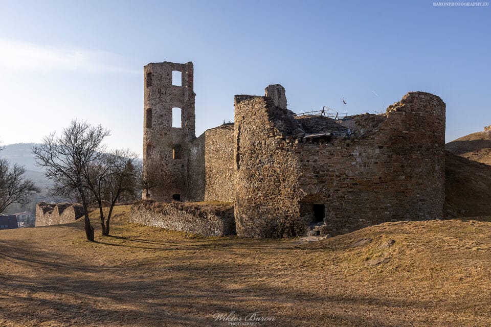 Zamek Plaveč 13 Zamek Plaveč, ruiny kamiennej warowni na wzgórzu w Słowacji, widok na mury, baszty i wysoką wieżę.