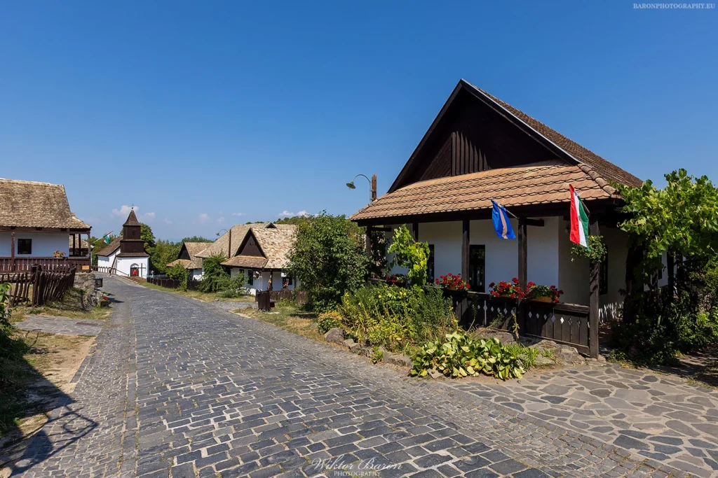 Hollókő, tradycyjna wieś UNESCO na Węgrzech z białymi domami i zamkiem na wzgórzu.